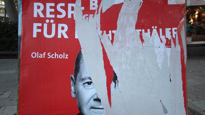 Symbolbild: Ein zerstörtes Wahlplakat der SPD mit Kanzlerkandidat Olaf Scholz hängt in der Innenstadt. (Quelle: imago images/R. Peters)
