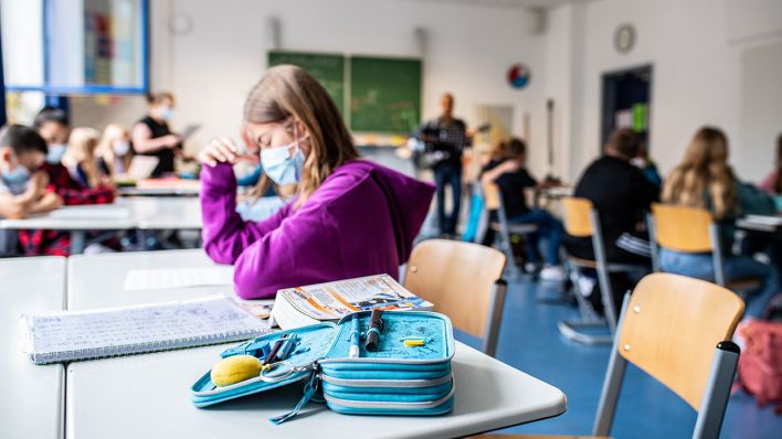 Archivbild: Eine Schülerin sitzt mit ihrer Maske in einem Klassenzimmer. (Quelle: dpa/G. Kirchner)
