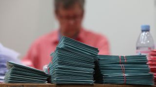 Wahlhelfer bereiten die Auszählung der Briefwahl-Unterlagen vor. Quelle: dpa/David Young