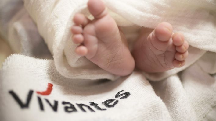 Symbolbild: Fuesse eines Neugeborenen mit Vivantes Logo. (Quelle: imago images/M. Waldmann)