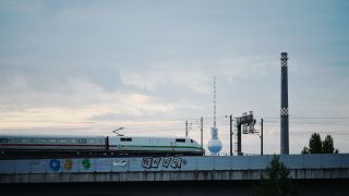 Ein Intercity-Express (ICE) fährt über eine Brücke in der der Stadt, im Hintergrund ist der Berliner Fernsehturm zu sehen. (Quelle: dpa/Sven Braun)