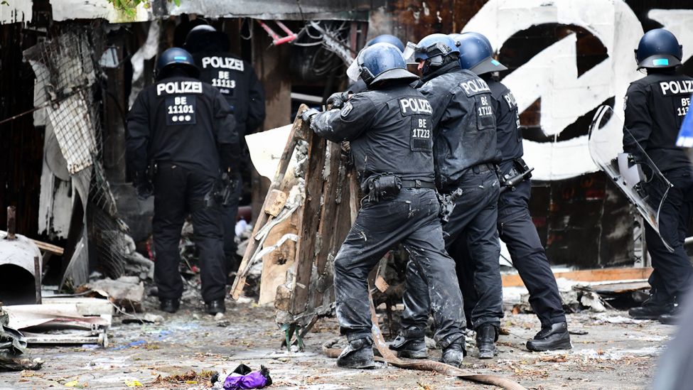 Polizisten räumen Barrikaden am Eingang der Bauwagensiedlung während der Räumung aus dem Weg. (Quelle: ddpa/Fabian Sommer)