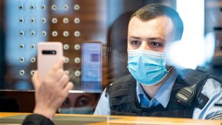 Ein Beamter der Bundespolizei am Flughafen kontrolliert eine Reisende aus Sankt Petersburg (Russland), einem Virusvariantengebiet (Bild: dpa/Fabian Sommer)
