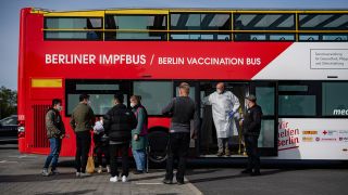 Symbolbild: Menschen stehen am 01.10.2021 auf dem Gelände des Dong Xuan Centers in Lichtenberg vor dem ersten Berliner Impfbus, um sich gegen Corona impfen zu lassen (Bild: dpa/Paul Zinken)