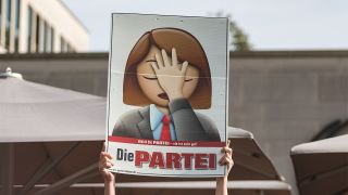 Eine Person hält im September in Fulda ein Plakat der Partei "Die Partei" in die Höhe (Bild: dpa/Müller)