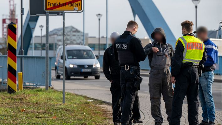 Zwei Polizisten kontrollieren auf der Grenzbrücke zwischen Deutschland und Polen drei Männer, die die Grenze zu Fuß überquerten. Bundesinnenminister Seehofer will den starken Anstieg unerlaubter Einreisen über die polnisch-deutsche Grenze im Kabinett zur Sprache bringen. (Quelle: dpa/Monika Skolimowska)