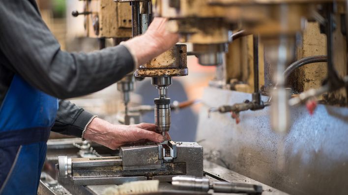 Ein Mitarbeiter bedient in der Produktionshalle der Firma Impulsa AG eine Maschine zur Verarbeitung von Metall. (Quelle: dpa/Monika Skolimowska)