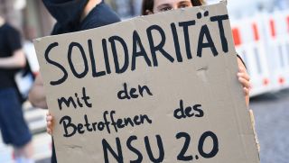 Ein Demonstrantin hält bei einer Kundgebung in der Wiesbadener Innenstadt ein Plakat mit der Aufschrift "Solidarität mit den Betroffenen des NSU 2.0". Quelle: Arne Dedert/dpa