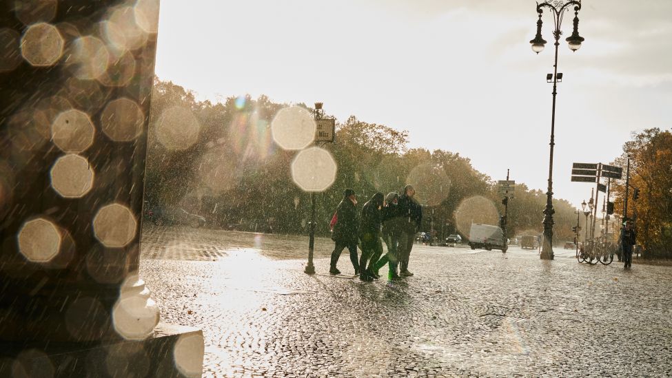 Berlin: Menschen gehen in Sturm und Regen am Brandenburger Tor vorbei. (Quelle: Annette Riedle/dpa)
