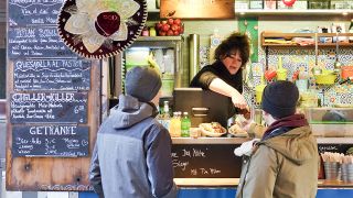Zwei Männer bestellen am 06.02.2019 auf dem Berlinale Street Food Markt auf dem Potsdamer Platz ihr vegetarisches Essen. (Quelle: dpa/Sven Braun)