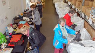 Archivbild: Freiwillige Helferinnen sortieren Kleidung für Geflüchtete. (Quelle: Patrick Pleul/dpa)