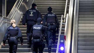 Drei Polizisten und eine Polizistin gehen über einen Bahnhof in Berlin. (Quelle: dpa/ Kira Hofmann)