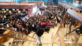 Passagiere warten in der Flughafenhalle auf ihre Abfertigung. (Quelle: dpa/Christophe Gateau)