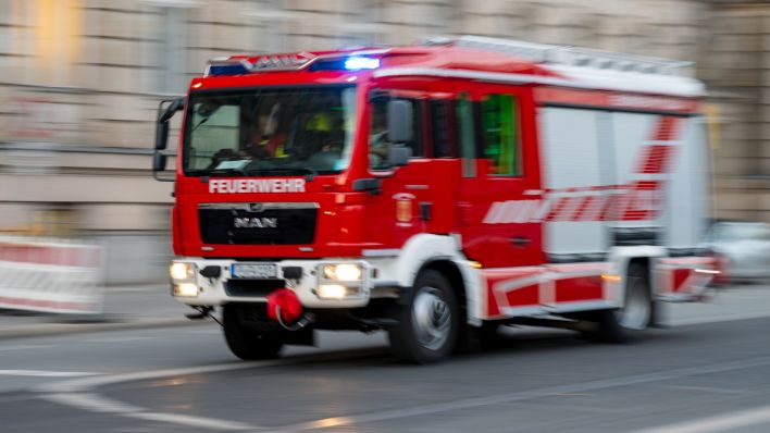 Ein Feuerwehrauto mit eingeschaltetem Blaulicht fährt zum Einsatz. (Quelle: dpa/Monika Skolimowska)