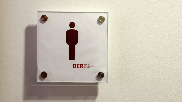 Das Hinweisschild auf die Männertoilette im Besucherzentrum des Hauptstadtflughafens BER in Schönefeld (Brandenburg), fotografiert am 11.04.2014. (Quelle: dpa/Ralf Hirschberger)