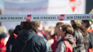 Archivbild: "Wir Streiken" und "GEW" steht auf zwei Flatterbändern hinter denen Teilnehmer eines Warnstreiks stehen (Bild: dpa/Klaus Dietmar Gabbert)