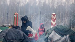 Auf diesem vom Staatlichen Grenzkomitee Belarus veröffentlichten Foto wärmen sich Migranten aus dem Nahen Osten und anderen Ländern an einem Feuer an der belarussisch-polnischen Grenze (Bild: dpa/The State Border Committee of the Republic of Belarus/AP)