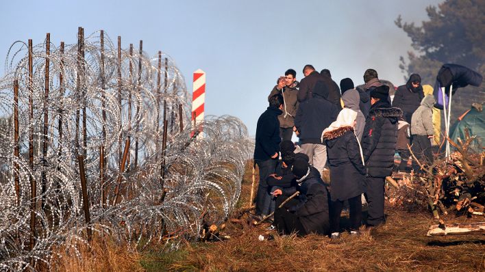 Migranten aus dem Nahen Osten und anderen Ländern versammeln sich vor einem Grenzzaun aus Stacheldraht an der belarusisch-polnischen Grenze bei Grodno Grodno (Bild: dpa/Leonid Shcheglov)