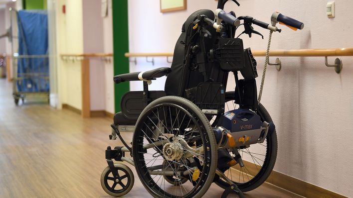Symbolbild: Ein Rollstuhl steht in einer Pflegeeinrichtung auf dem Flur. (Quelle: dpa/Britta Pedersen)