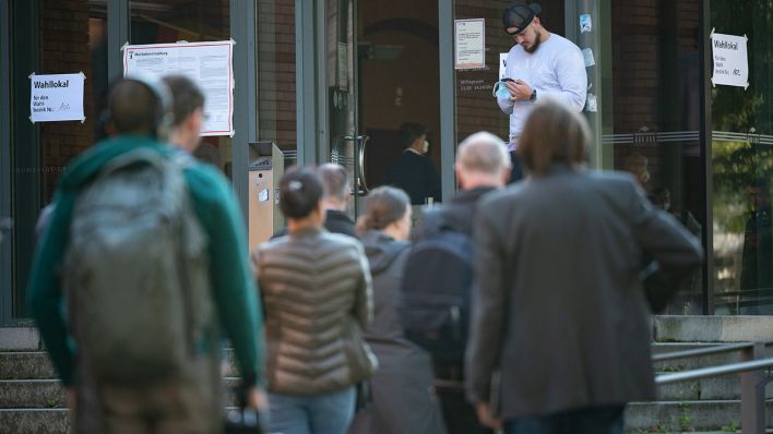 Wählerinnen und Wähler warten kurz vor 9 Uhr vor dem Wahllokal 102. (Quelle: dpa/Sebastian Gollnow)