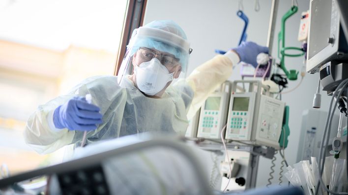 Symbolbild: Ein Intensivpfleger arbeitet auf der Intensivstation des Krankenhauses Bethel Berlin an eine an Covid-19 erkrankten Patientin. (Quelle: dpa/Kay Nietfeld)