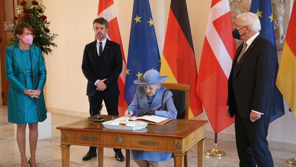 Margrethe II., Königin von Dänemark (M) trägt sich ins Gästebuch bei der Begrüßung durch den Bundespräsidenten Frank-Walter Steinmeier (r) und seine Frau Elke Büdenbender im Schloss Bellevue ein. (Quelle: dpa/Wolfgang Kumm)