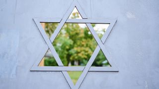 Symbolbild: Auf dem Eingangstor des Judengangs am jüdischen Friedhof Schönhauser Allee ist ein Fenster in Form eines Davidsterns, durch das man in den grünen Gang sehen kann. (Quelle: dpa/A. Riedl)