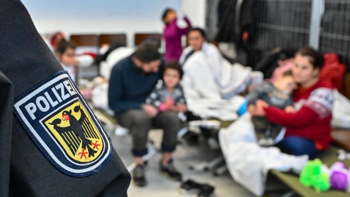 Familien sitzen in der neu eingerichteten zentralen Bearbeitungstelle der Bundespolizei und des Bundesamtes für Migration und Flüchtlinge (BAMF). Quelle: Patrick Pleul/dpa