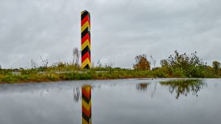 In den Nationalfarben Deutschlands steht ein Grenzpfeiler auf einem Deich nahe dem deutsch-polnischen Grenzfluss Oder. (Bild: dpa/Patrick Pleul)