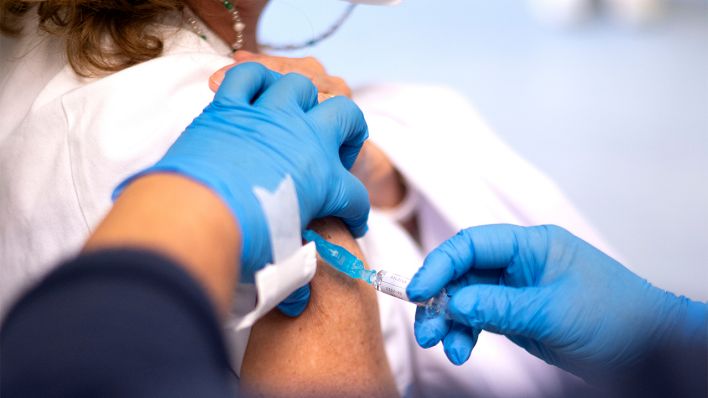 Symbolbild: Eine Frau erhält eine Grippeimpfung (Bild: dpa/Alberto Ortega)