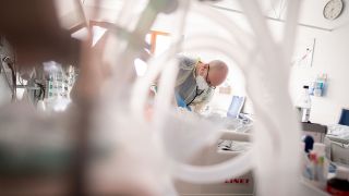 Intensivpfleger Rüdiger Piske arbeitet auf der Intensivstation des Krankenhauses Bethel Berlin an einem Patienten (Bild: dpa/Kay Nietfeld)