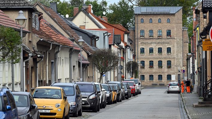 Symbolbild: Autos parken am Rand der Mühlenstraße in der Innenstadt von Zehdenick. Am Ende der Straße steht das Gebäude der Stadtwerke. (Quelle: dpa/S. Stache)