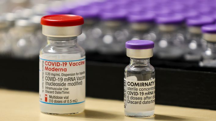 Symbolbild: Die beiden Corona-Impfstoffe von Moderna (l) und Biontech in Ampullen stehen in Ampullen nebeneinander. (Quelle: dpa/J. Woitas)