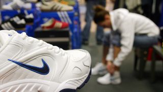 Symbolbild: Kundin beim Anprobieren von Nike-Sportschuhen in einem Sportgeschäft. (Quelle: dpa/J. Keystone)