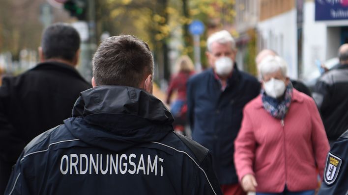 Symbolbild: Mitarbeiter vom Ordnungsamt kontrollieren, ob die Passanten auf der Bergmannstraße die Maskenpflicht einhalten und eine Mund-Nase-Bedeckung tragen. (Quelle: dpa/K. Hofmann)