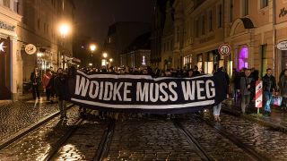 Mit einem Schild mit der Aufschrift "Woidke muss weg" marschieren Teilnehmer einer Demonstration gegen Corona-Maßnahmen entlang des Cottbuser Altmarktes. (Quelle: dpa/Frank Hammerschmidt)
