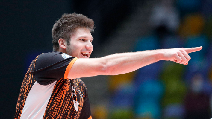 Volleyballer Ruben Schott zeigt lachend mit dem rechten Arm nach vorne (Quelle: IMAGO/Marcel Lorenz)