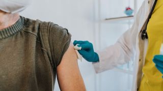 Patient lässt sich von seiner Hausärztin eine Corona-Impfung verabreichen (Bild: imago images/Mareen Fischinger)