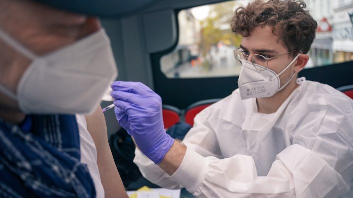 Der Arzt Gabriele Loi verabreicht eine Impfung mit Comirnaty von BioNTech/Pfizer in einem Impfbus (Bild: dpa/Jlrg Carstensen)
