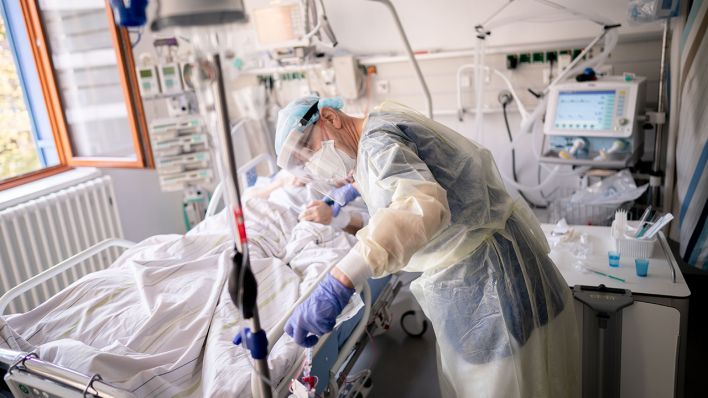 Symbolbild: Ein Intensivpfleger arbeitet am 20.04.2021 auf der Intensivstation eines Krankenhauses an einer an Covid-19 erkrankten Patientin. (Quelle: dpa/Kay Nietfeld)