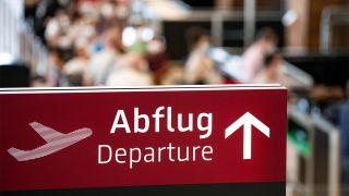 Ein Schild im Flughafen Berlin Brandenburg (BER) weist auf den Abflug-Bereich in der Haupthalle hin. (Quelle: dpa/Fabian Sommer)