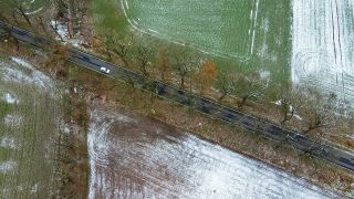 Schnee liegt am 04.12.2021 auf den Feldern neben einer Straße im Landkreis Oder-Spree im Osten des Landes Brandenburg (Luftaufnahme mit einer Drohne) (Quelle: dpa/Patrick Pleul)