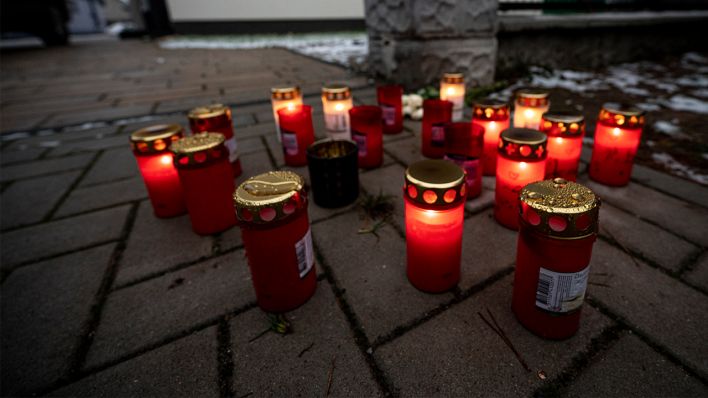 Vor dem Einfamilienhaus in Senzig, einem Ortsteil der Stadt Königs Wusterhausen im Landkreis Dahme-Spreewald, stehen am 05.12.2021 Kerzen. Die Polizei hat dort fünf Tote in einem Wohnhaus gefunden. (Quelle: dpa/Fabian Sommer)