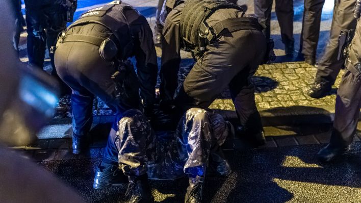 Polizeibeamte halten am 18. Dezember einen Demonstranten in Cottbus fest. (Quelle: dpa/Frank Hammerschmidt)