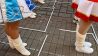 Funkenmariechen von Karnevalvereinen stehen mit Abstand zwischen Zollstöcken auf dem Boden zu Beginn der fünften Jahreszeit am 11.11.21 (Quelle: dpa / Patrick Pleul).