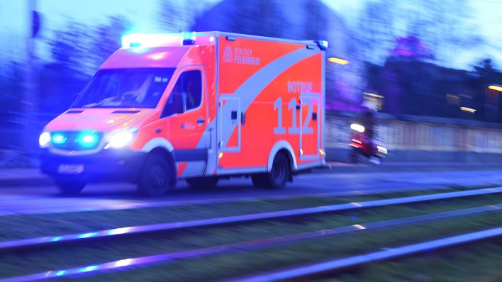Ein Rettungswagen der Feuerwehr fährt mit Blaulicht auf der Prenzlauer Allee, parallel verlaufen die Schienen der Straßenbahn. (Quelle: dpa/Sonja Wurtscheid)