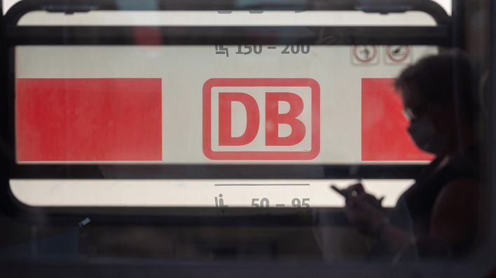 Ein Reisender mit Mund- und Nasenschutz sitzt in einem Zug der Deutschen Bahn (Quelle: dpa/Sebastian Gollnow)
