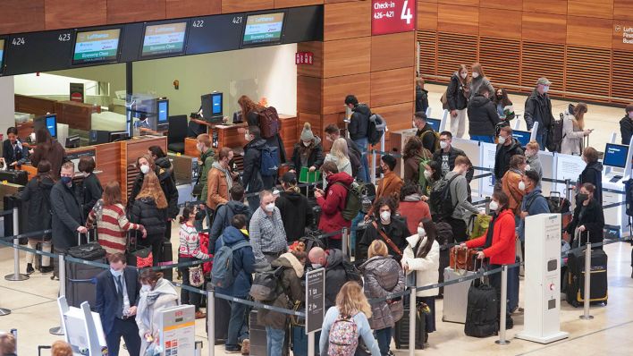 Eine Warteschlange hat sich am Flughafen BER an einem Check-in-Schalter gebildet. (Quelle: dpa/J. Carstensen)
