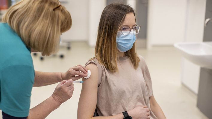 Symbolbild: Eine junge Frau erhält eine Booster-Impfung zum Schutz vor dem neuartigen Corona-Virus. (Quelle: dpa/L. McBurney)