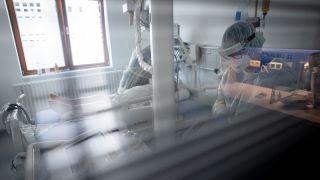 Intensivpflegerin und Röntgen-Assistentin bereiten auf der Intensivstation einen an Covid-19 erkrankten Patientin für eine Röntgenaufnahme der Lunge vor. (Quelle: dpa/Kay Nietfeld)